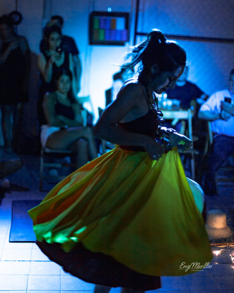 Bailarina con pollera verde girando durante una función en Nido Centro de Artes