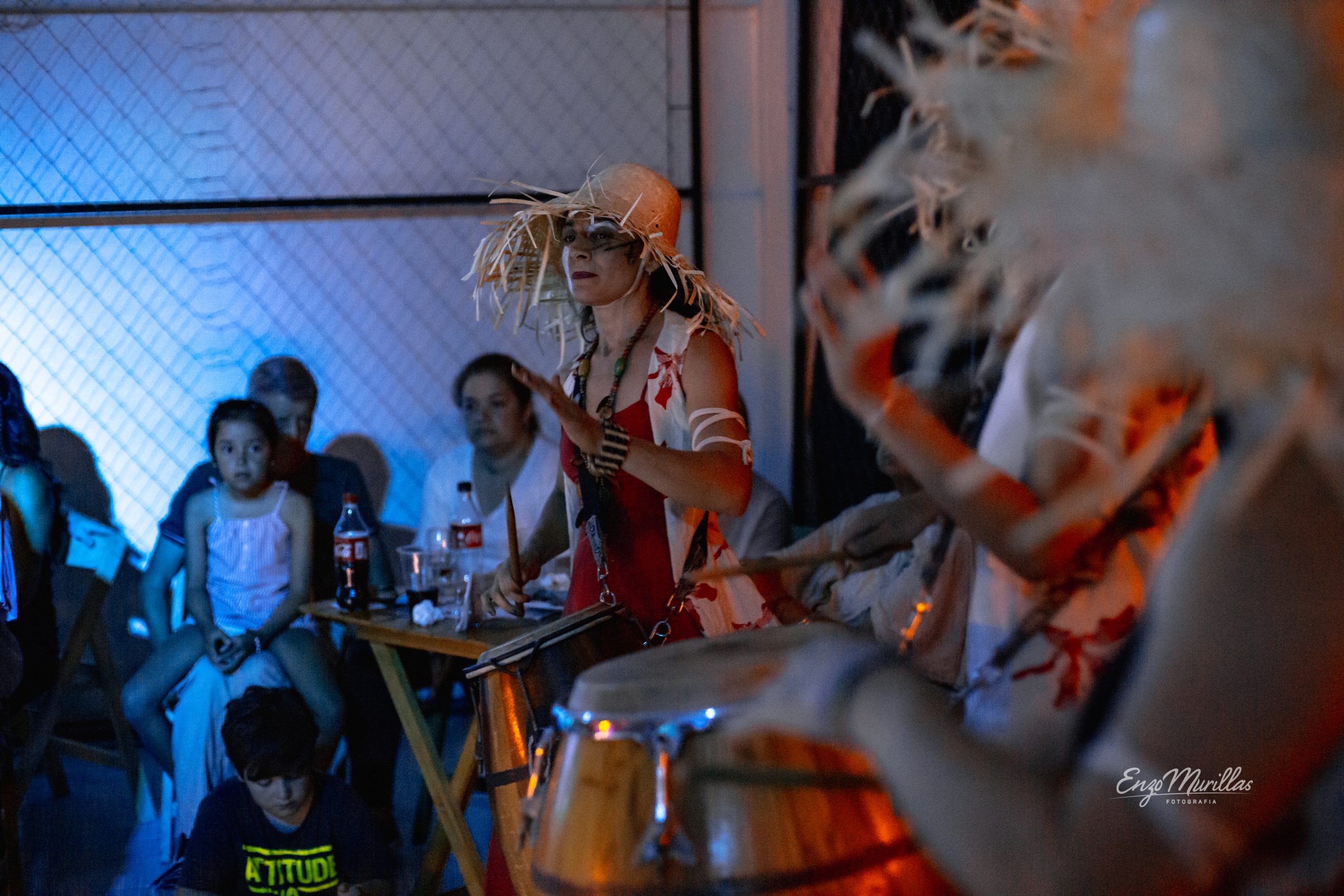 Músicos con sombreros de paja tocando tambores ante el público en un show de Nido Centro de Artes, Resistencia